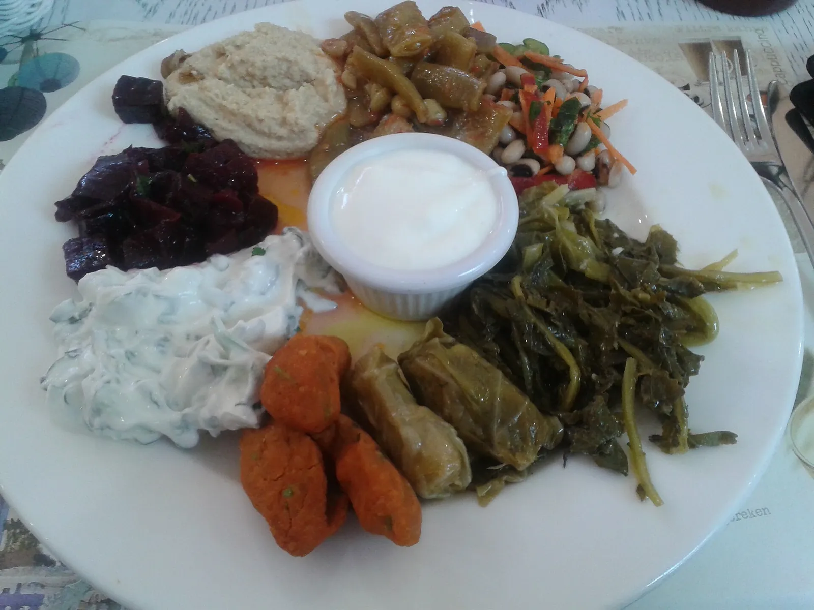 Colourful Turkish meze platter with dips and greens