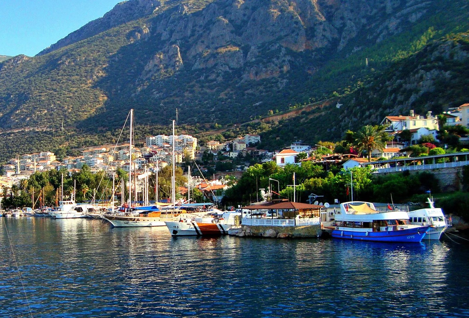 Boats in Kaş harbour below green mountains
