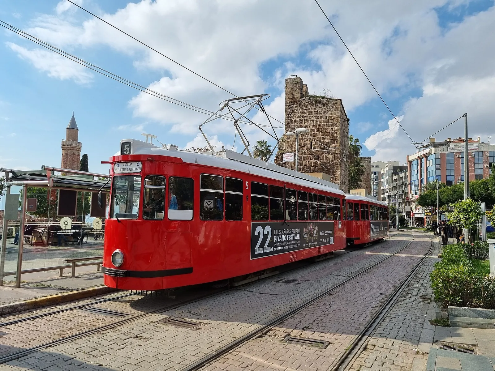 Red heritage tram rolling past the old town walls