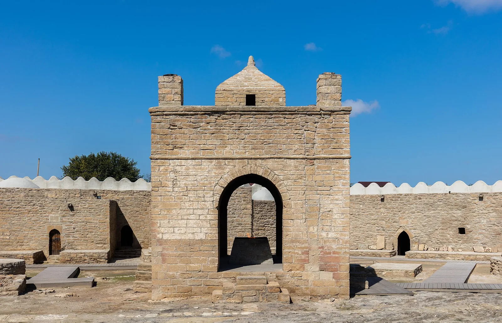 The stone fire altar at Ateshgah under a bright blue sky