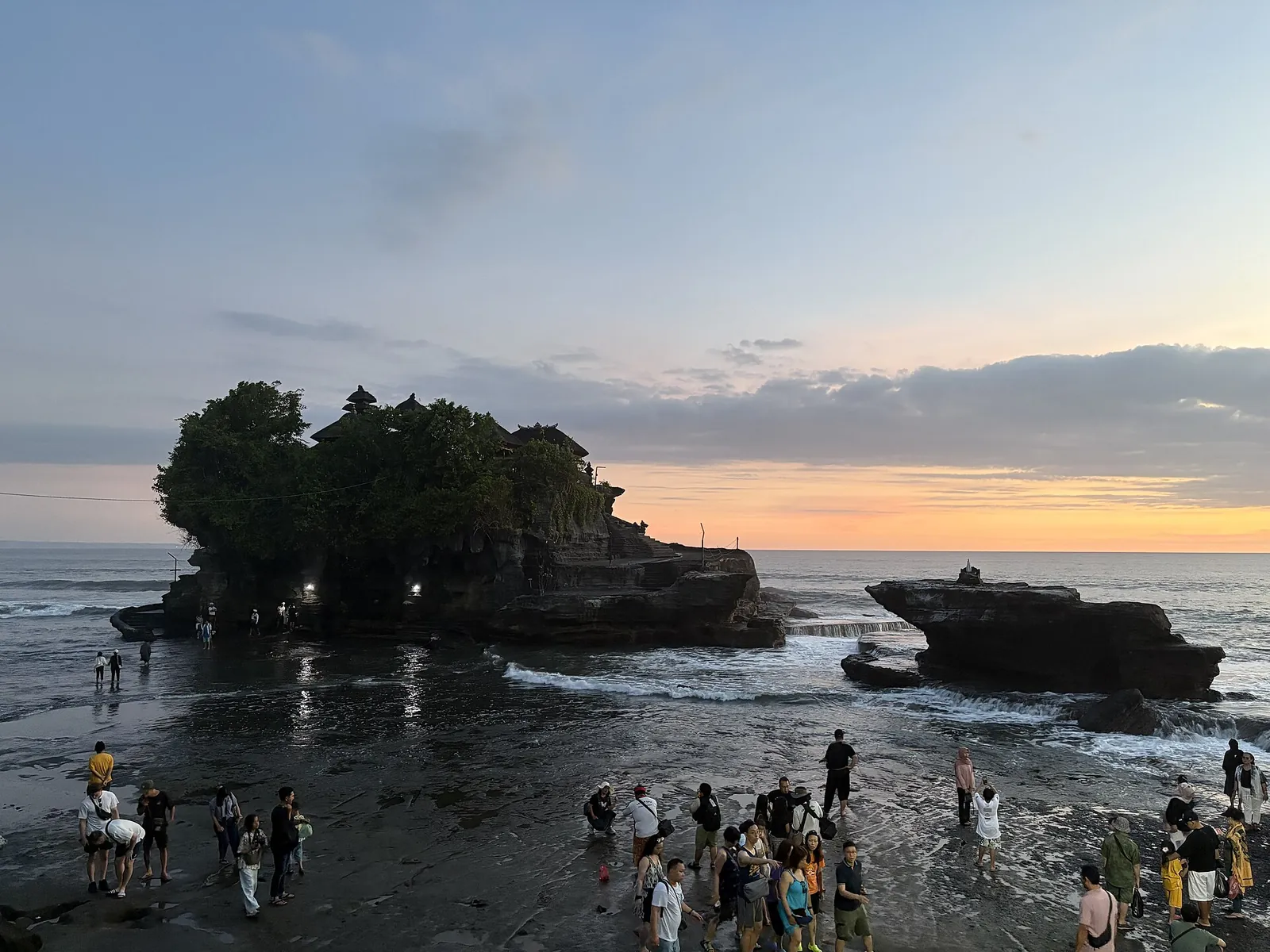 Golden sunset glow behind Tanah Lot temple