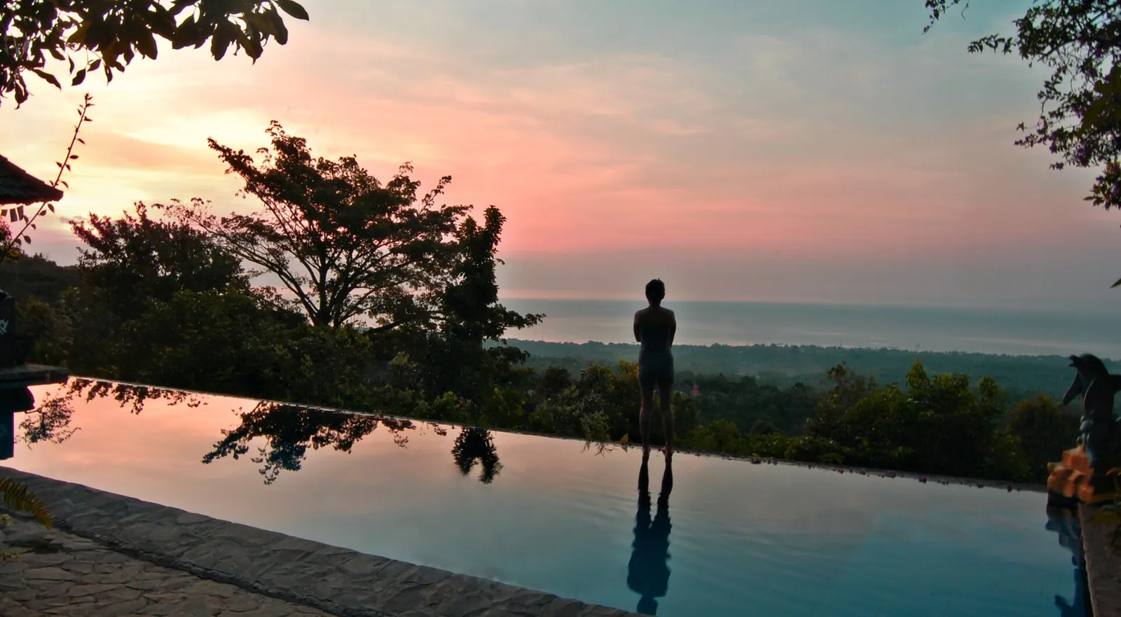 Infinity pool glowing pink at dusk in Bali
