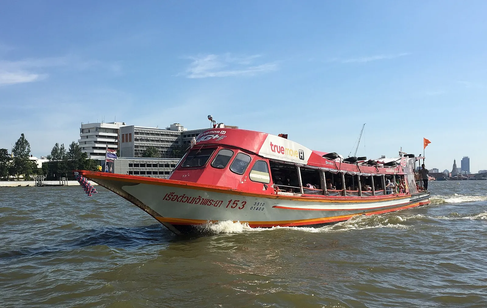 An orange-flag Chao Phraya Express Boat on the river