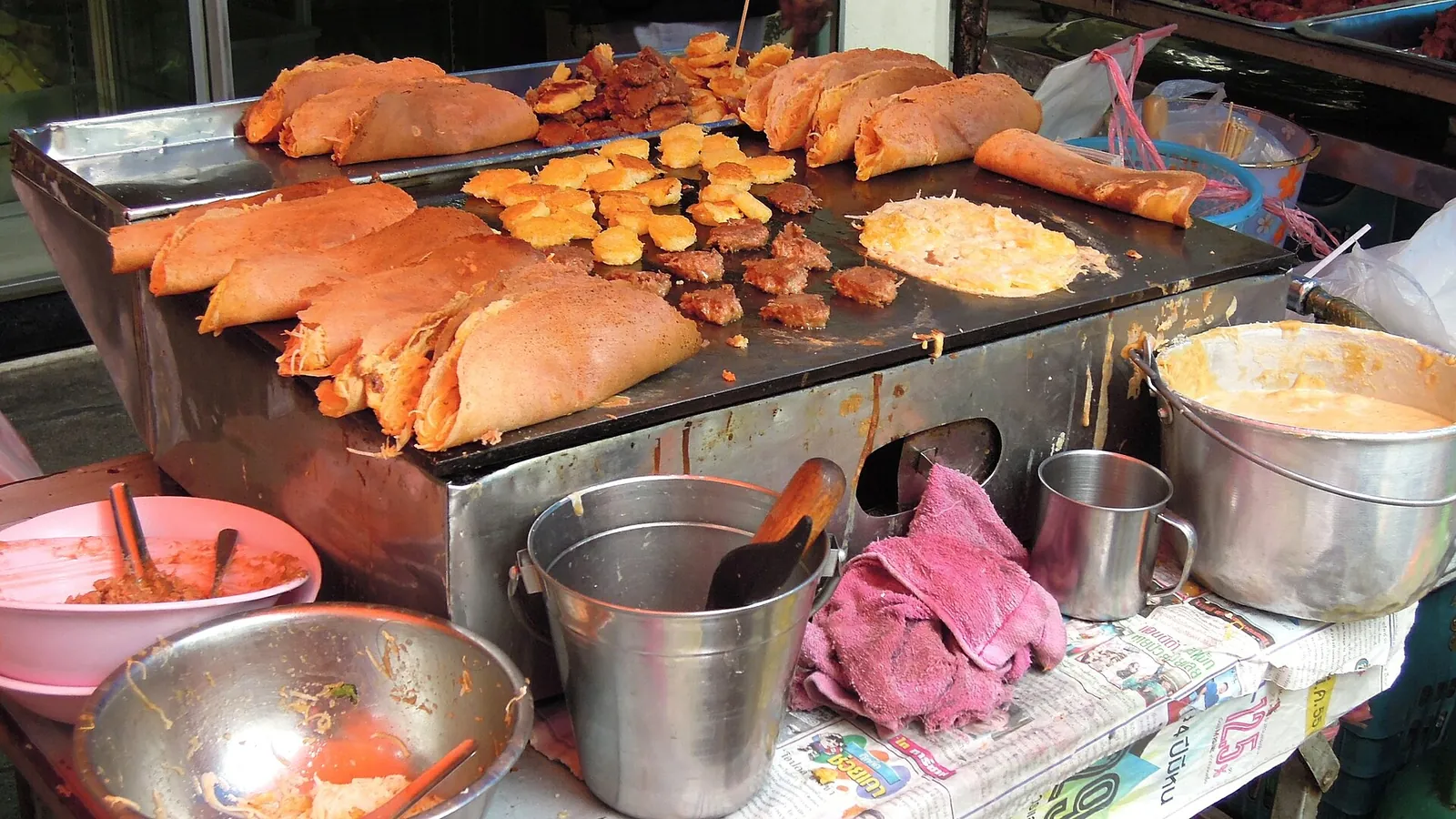 Golden snacks on a griddle at a Bangkok street food stall