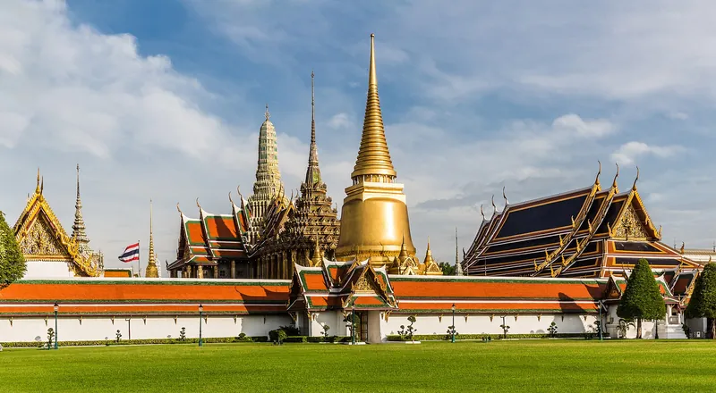 Golden spires of Wat Phra Kaew under a bright blue sky