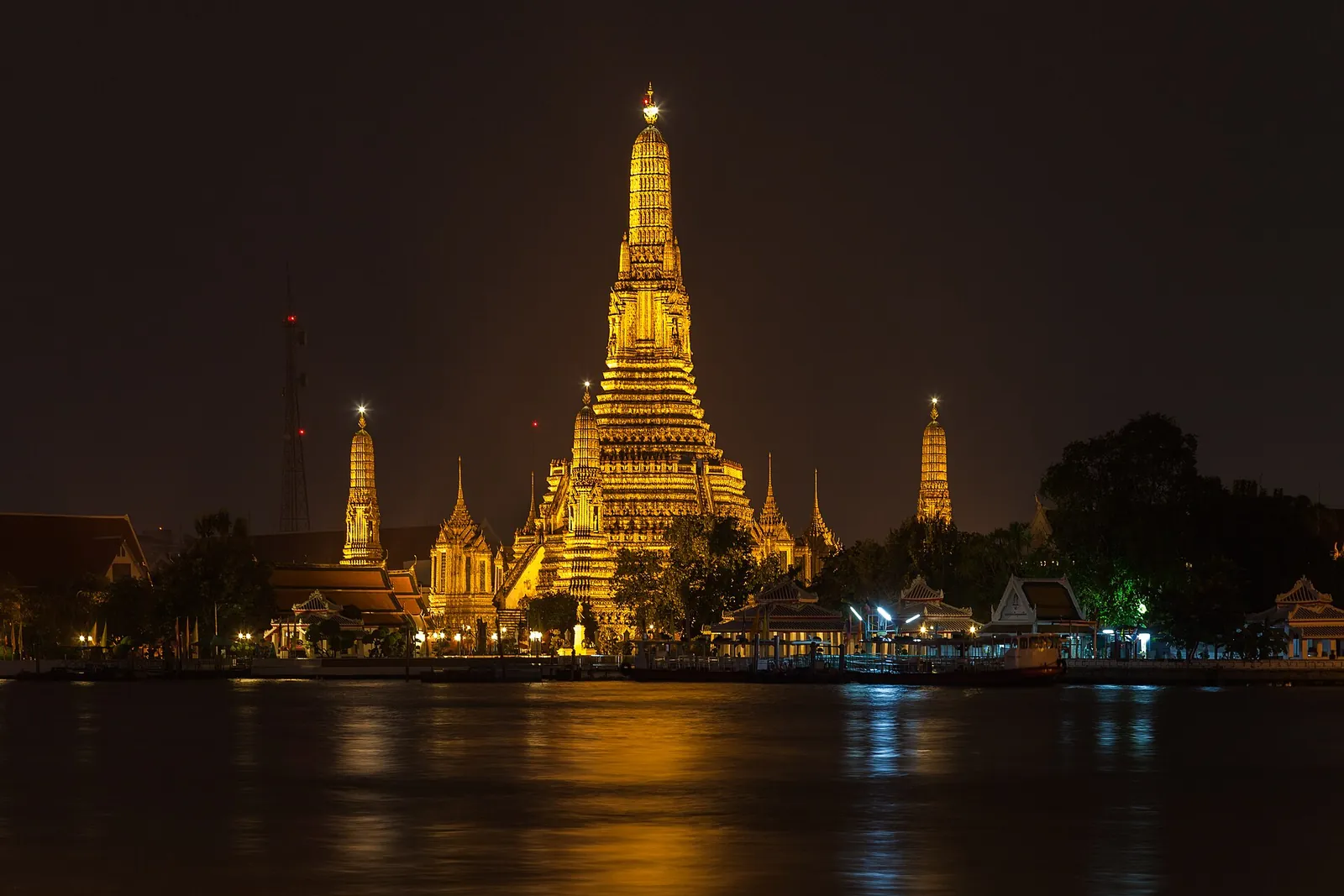 Wat Arun glowing across the Chao Phraya at night