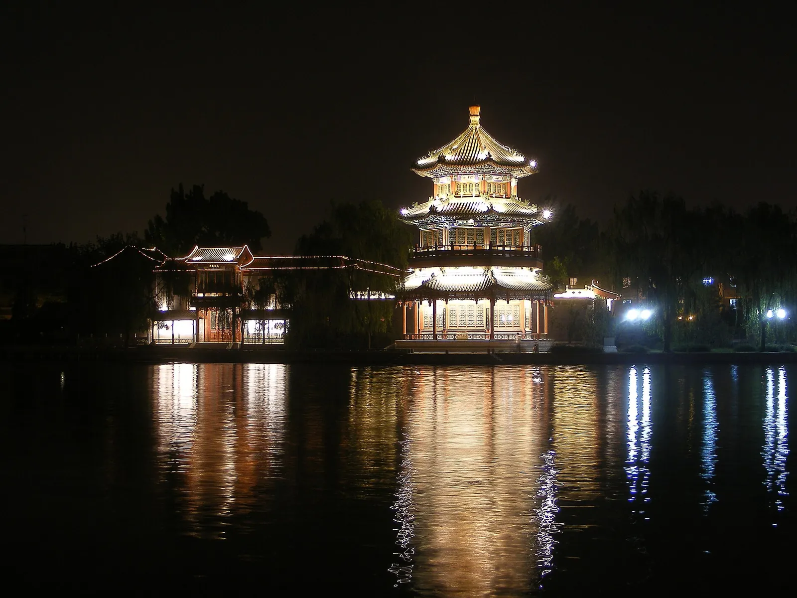 Lit pavilion reflected in Houhai Lake at night