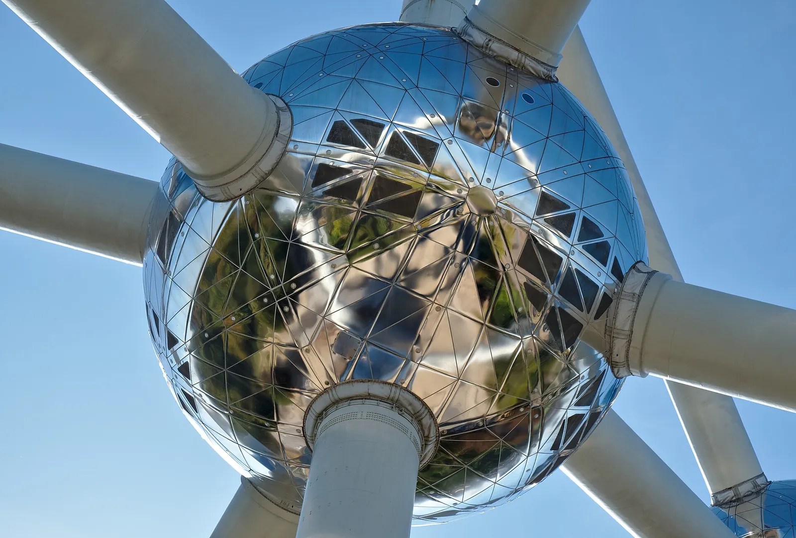 A shiny Atomium sphere against a clear blue sky
