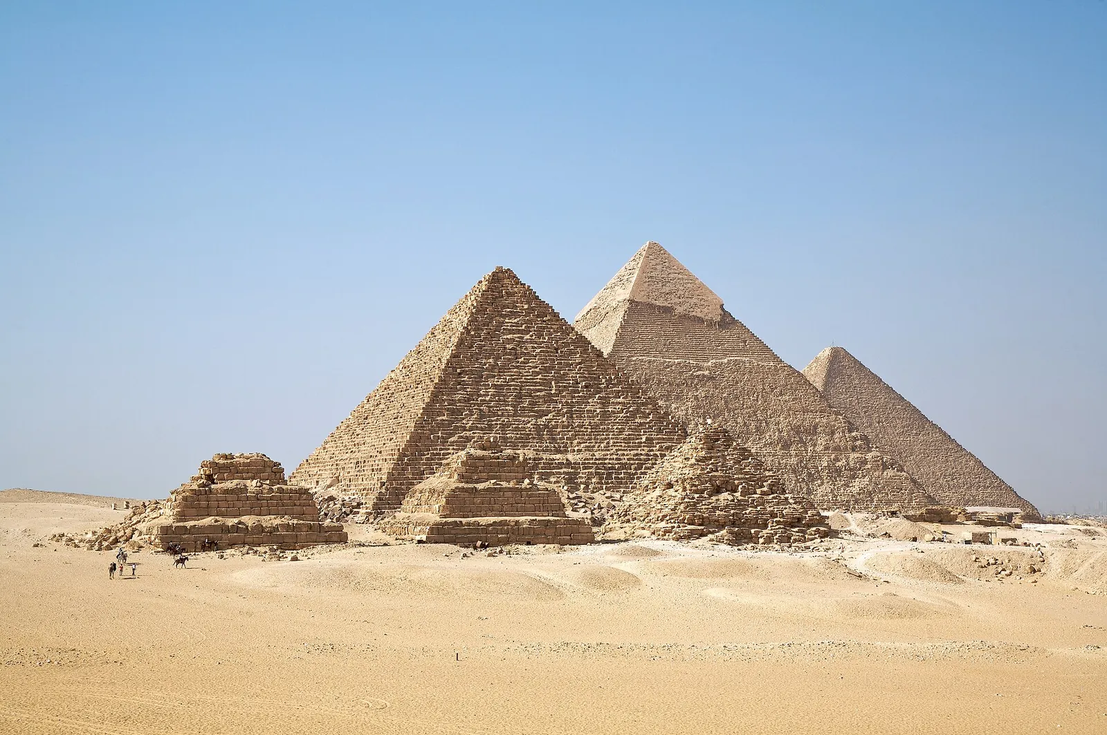 The three pyramids of Giza under a clear blue sky
