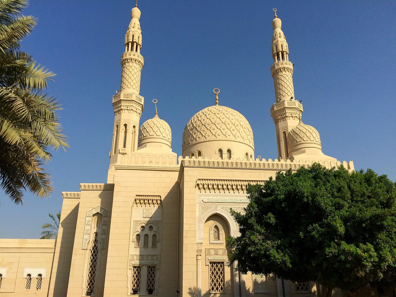 Jumeirah Mosque's domes and minarets against a blue sky