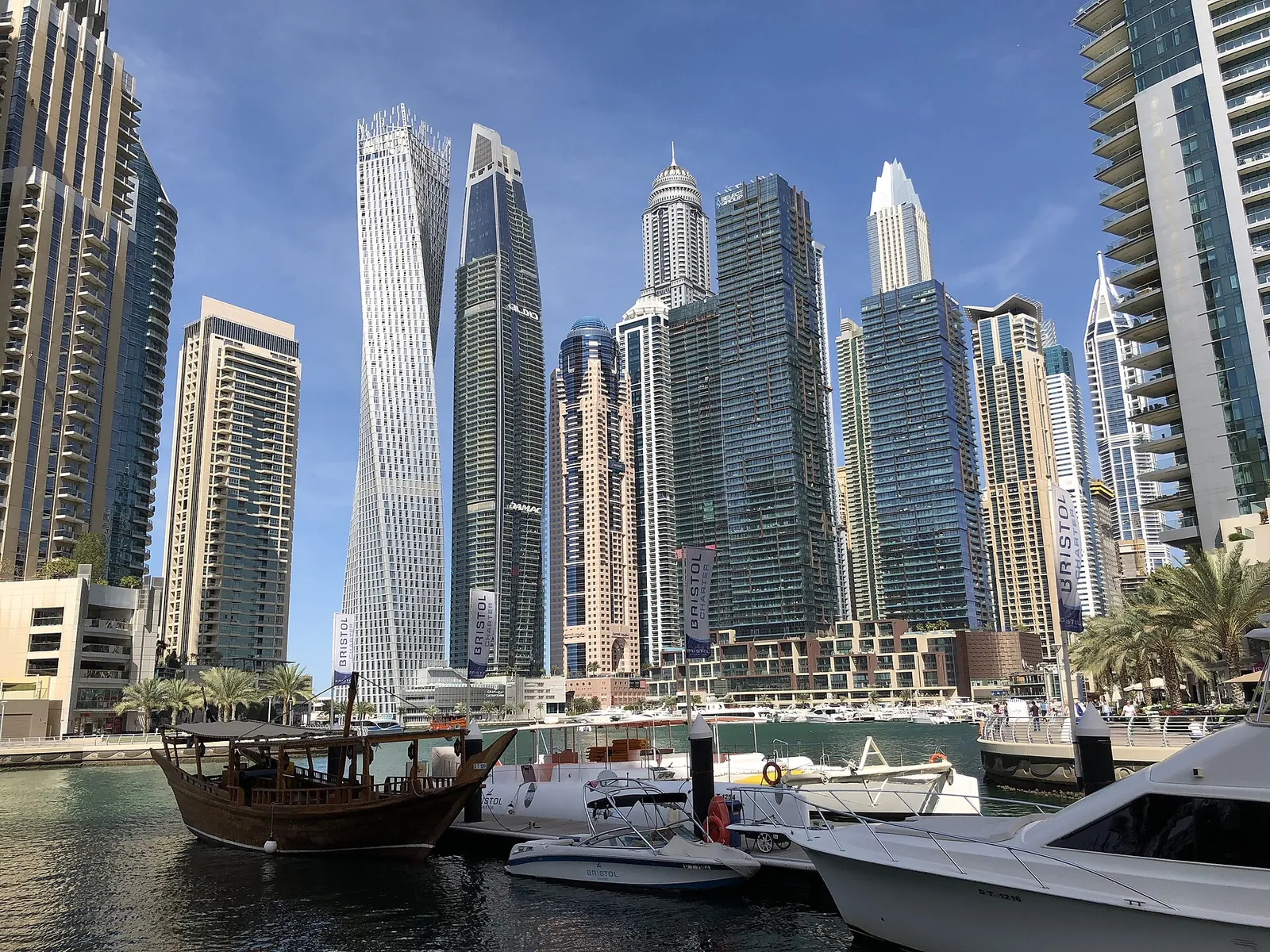 Dubai Marina towers and boats under a blue sky