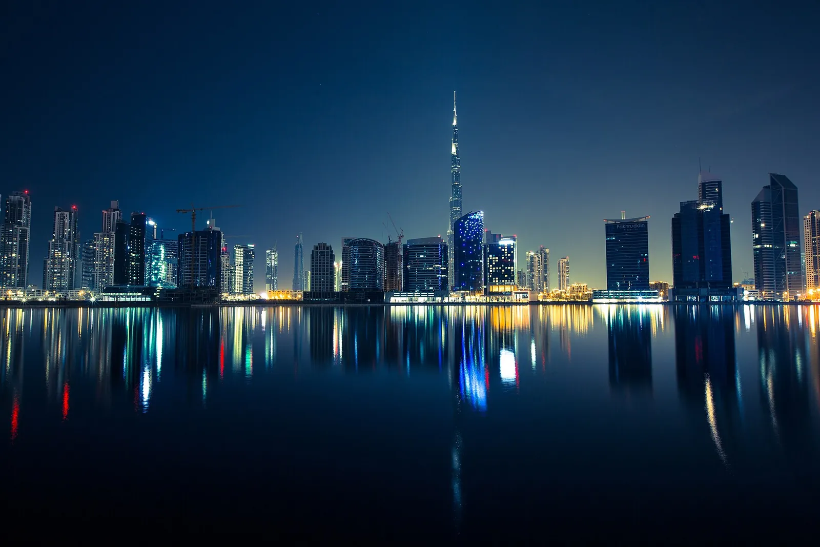 Dubai skyline and Burj Khalifa reflected at night