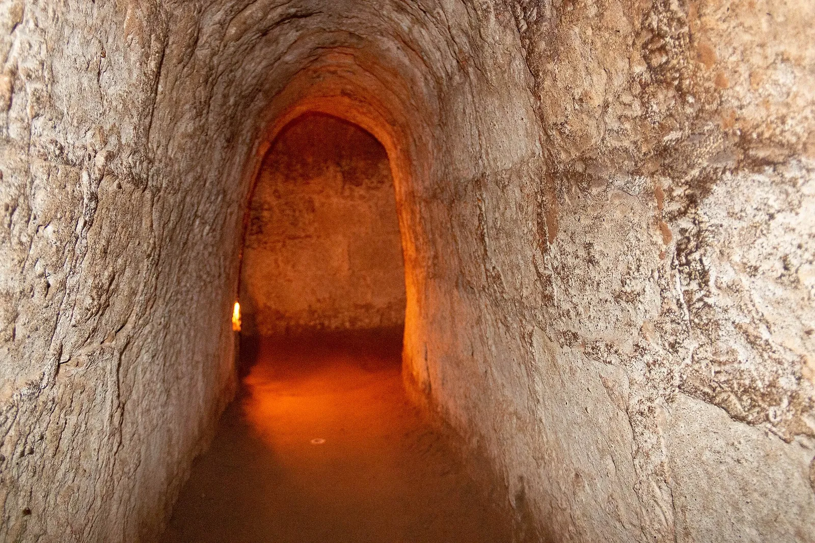 A narrow, lamp-lit passage in the Cu Chi Tunnels