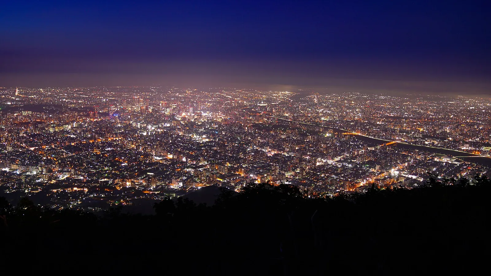 Sapporo's city lights glittering below Mt. Moiwa at dusk