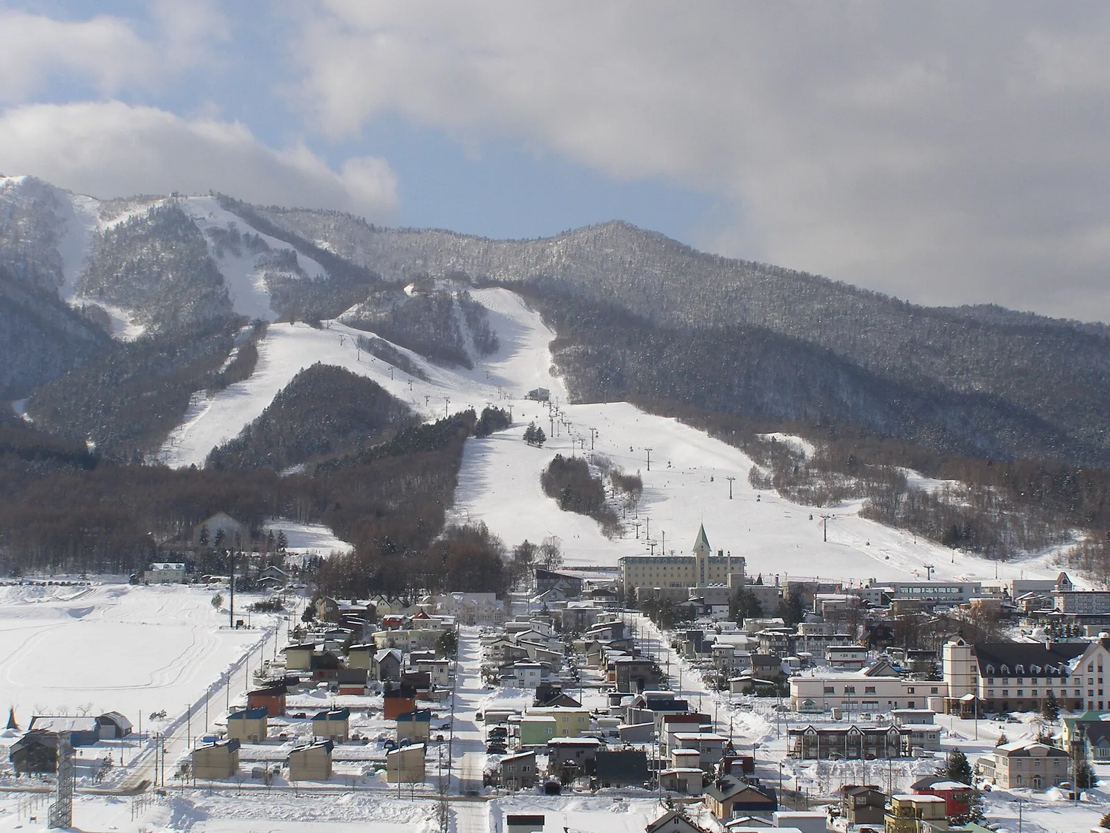 Snowy ski runs above Furano town in winter
