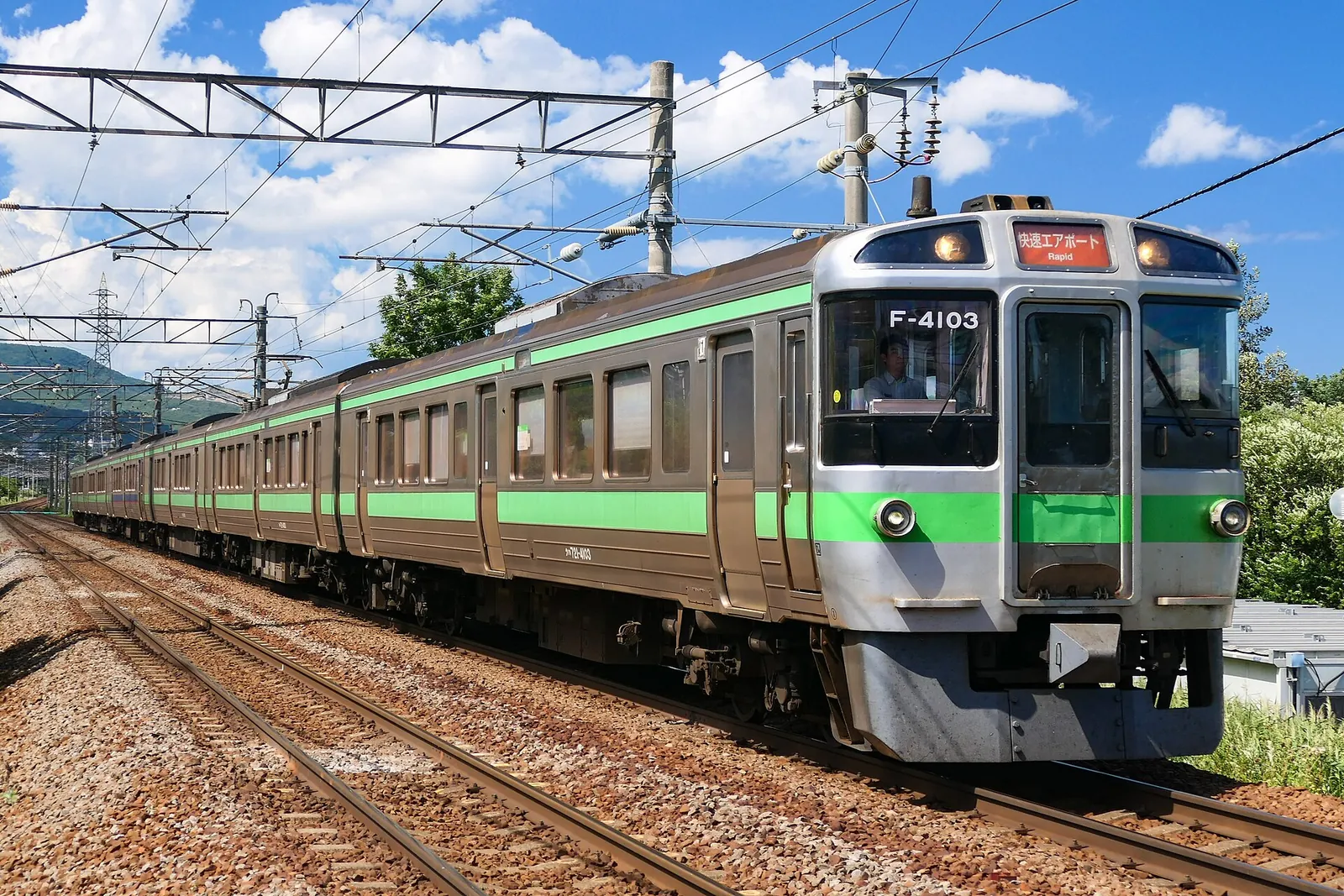 A JR Hokkaido train running under summer skies