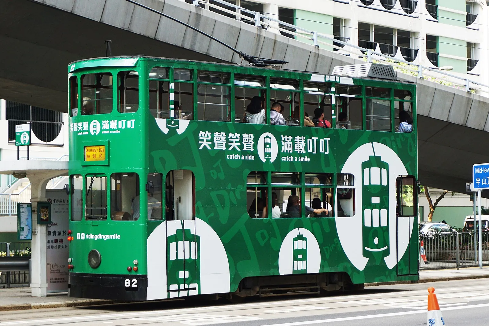 A green double-decker Ding Ding tram in the city