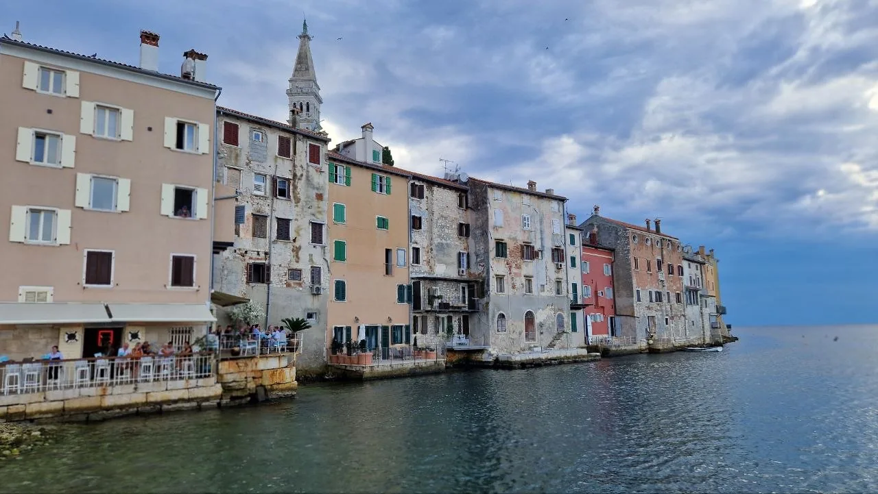Rovinj's old town rising straight out of the sea, with pastel houses on the water and the church tower above