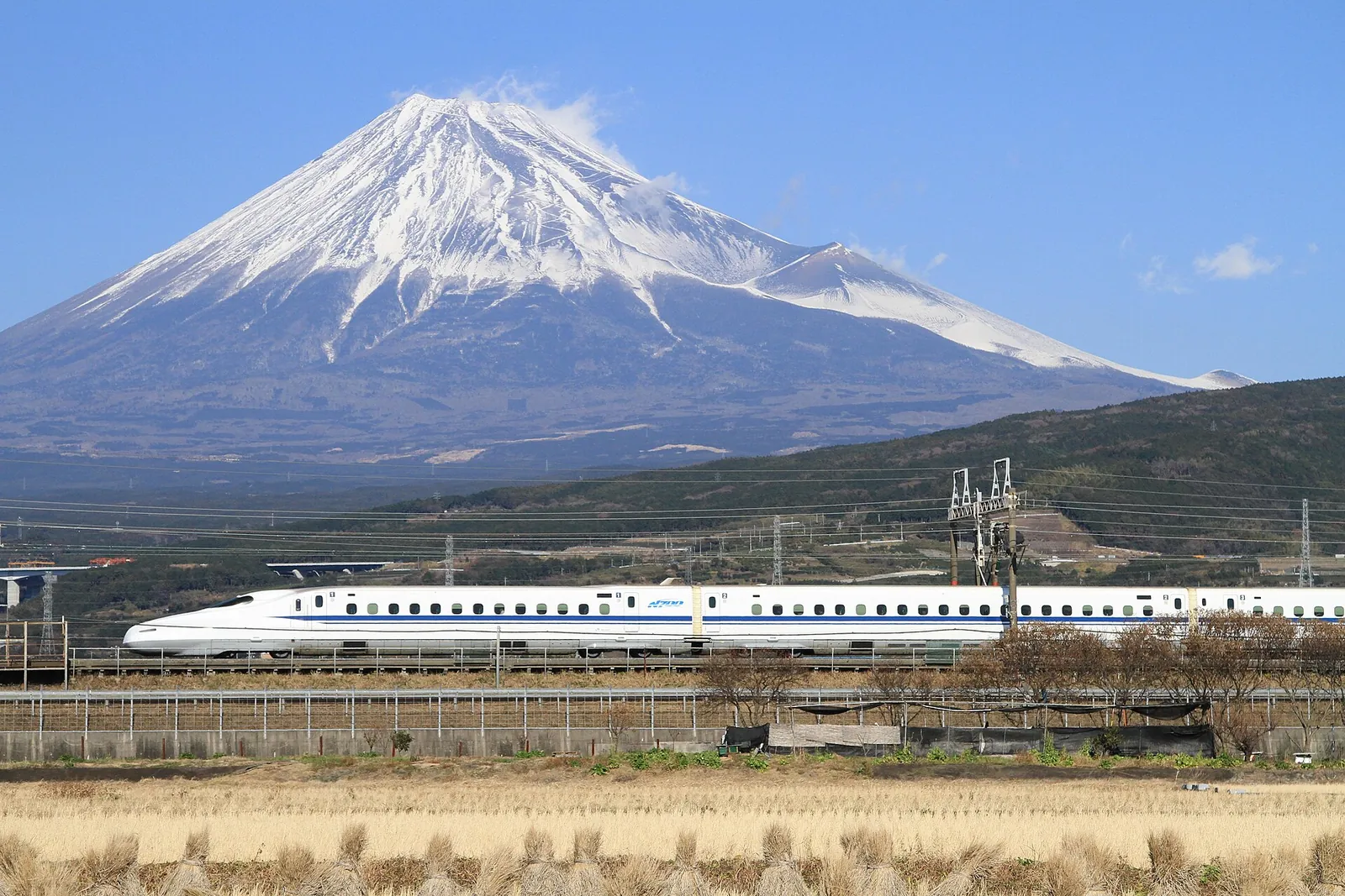 Shinkansen bullet train gliding past Mount Fuji