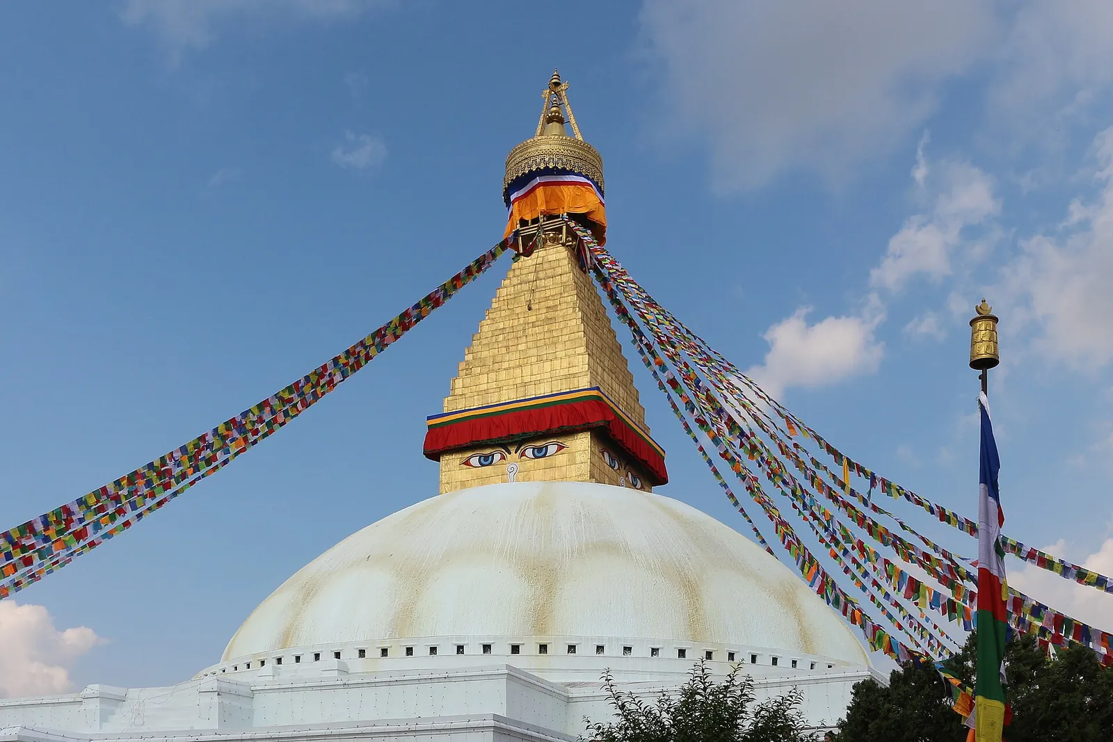 Prayer flags fluttering over the white dome of Boudha Stupa