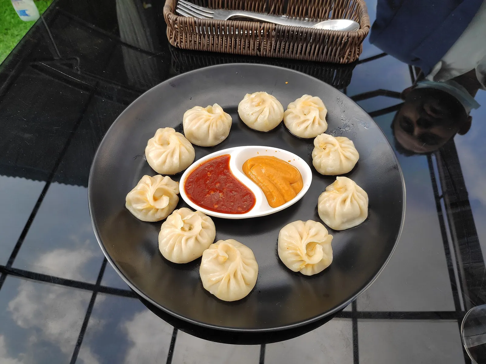 A plate of steamed momos with two dipping sauces