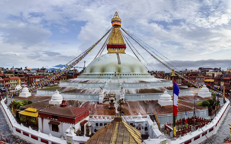 Boudhanath Stupa strung with prayer flags under a blue sky