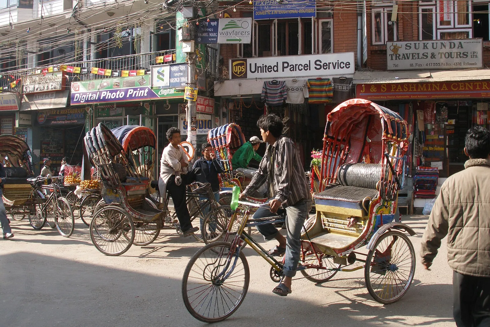 Cycle rickshaws on a busy, sunny street in Thamel