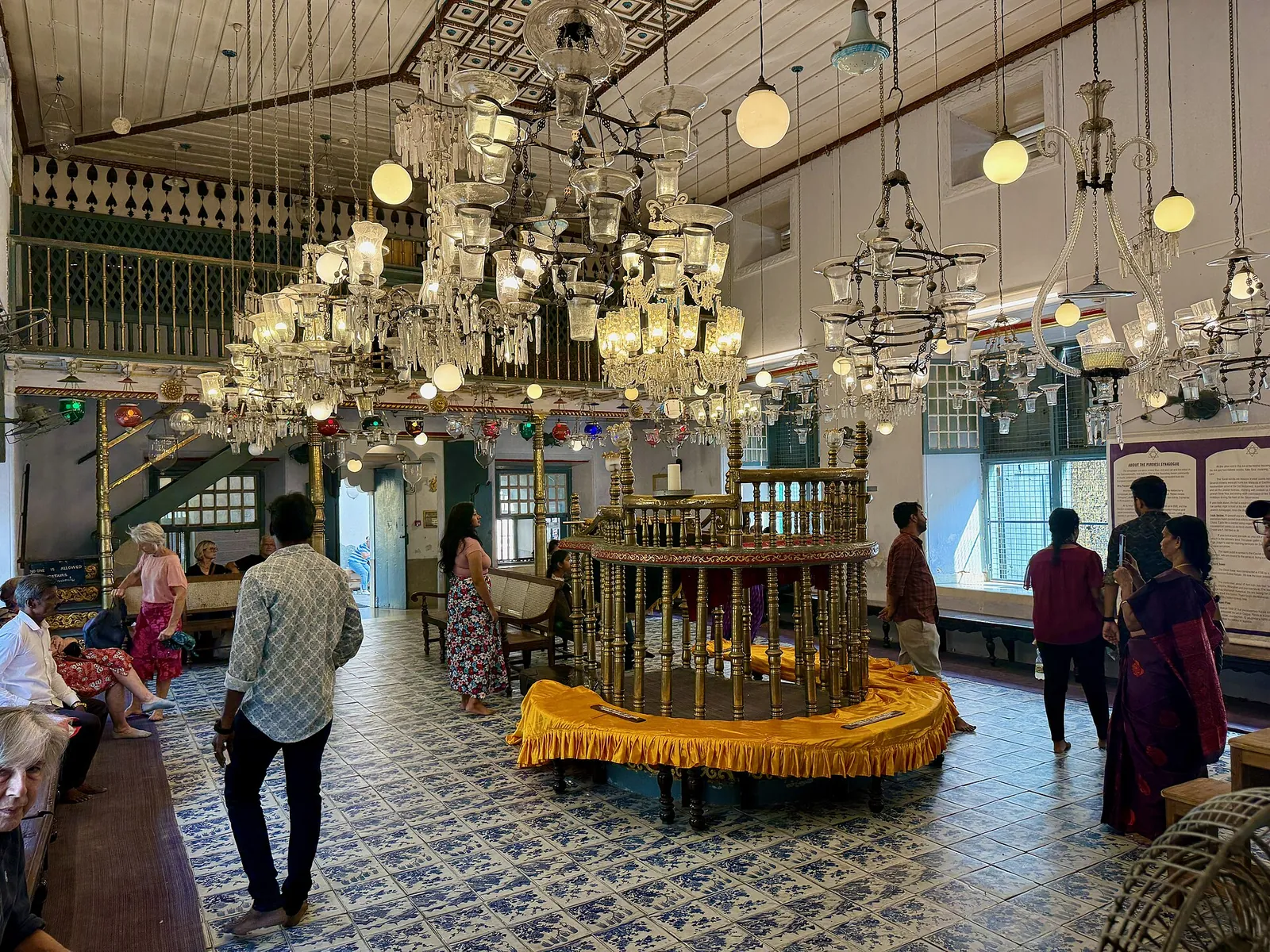 Chandeliers and blue floor tiles inside the Paradesi Synagogue
