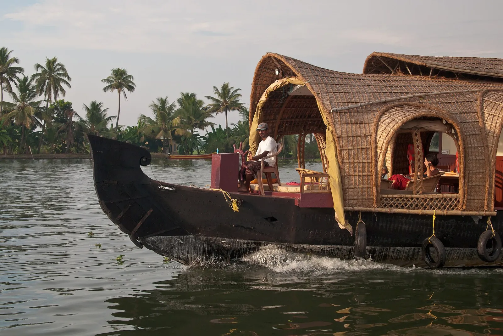 Traditional kettuvallam houseboat cruising the Kerala backwaters