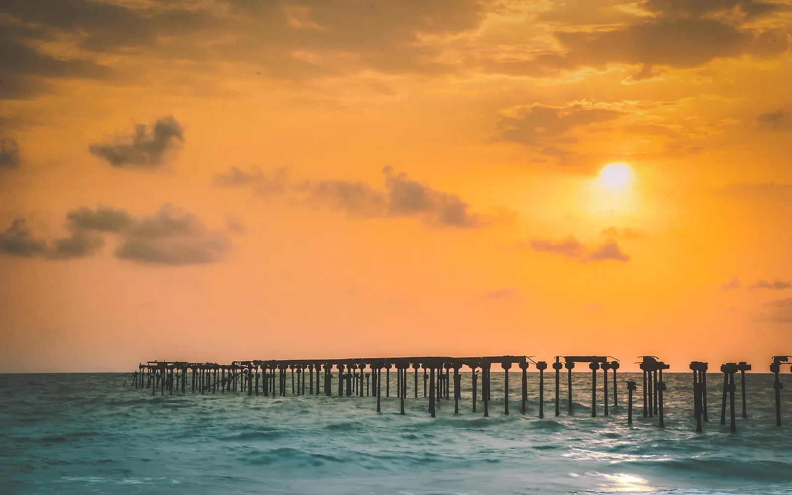 Golden sky over the old pier at Alappuzha Beach