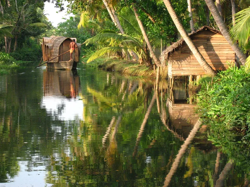 Palm-fringed backwater canal with a houseboat in Kerala