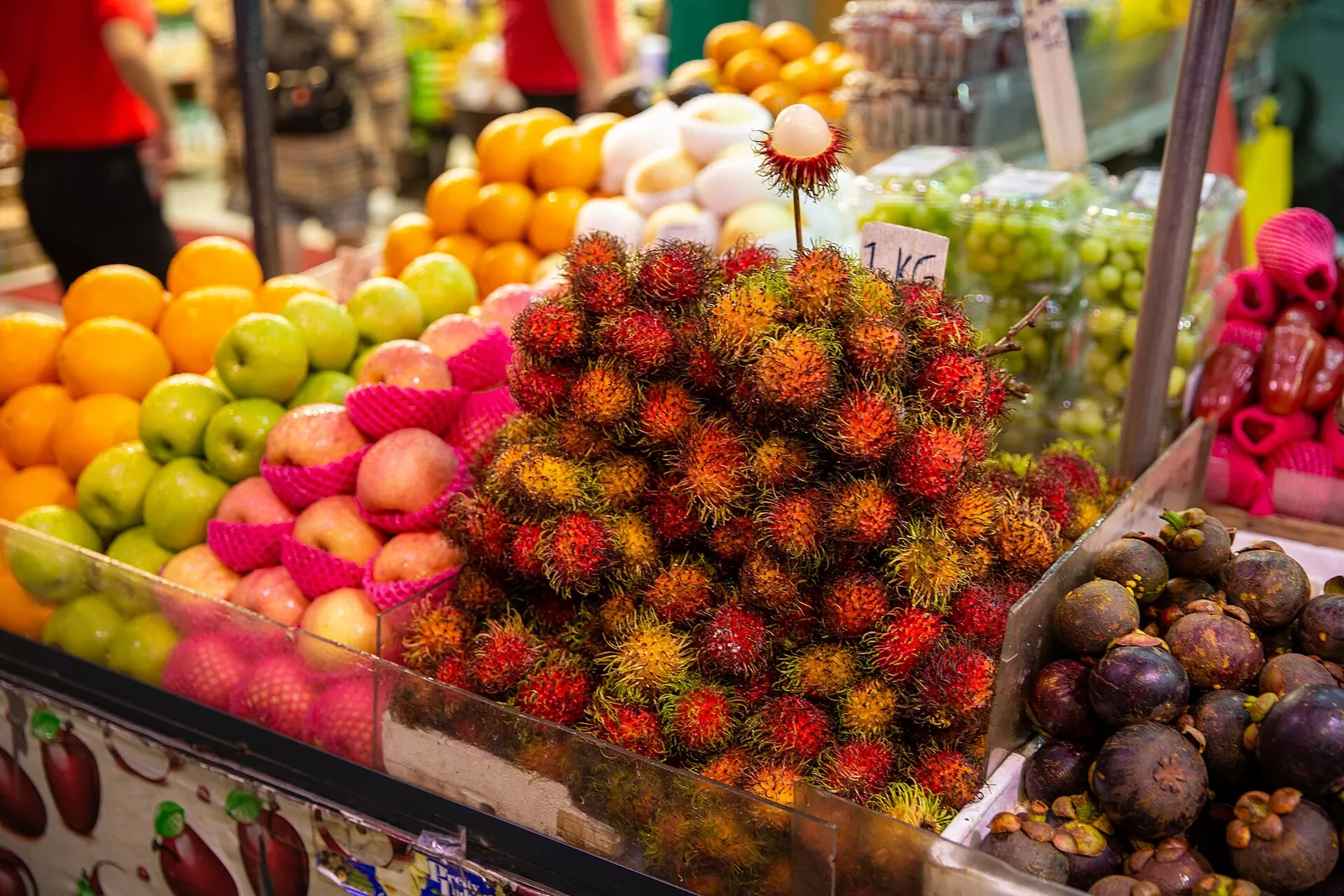 Rambutans, mangosteens and fresh fruit piled high at a market stall