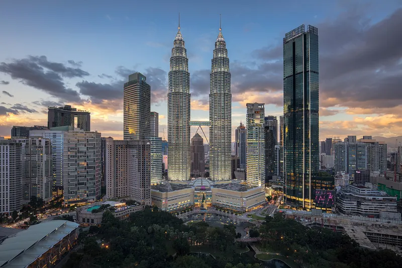 Petronas Twin Towers glowing at sunset over Kuala Lumpur