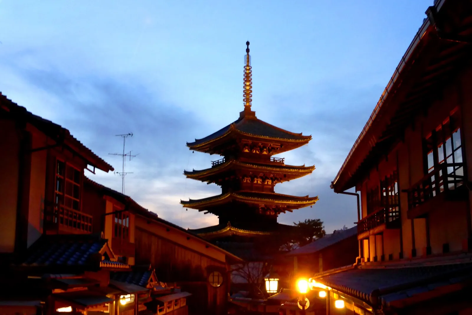 Yasaka Pagoda glowing at dusk between wooden houses