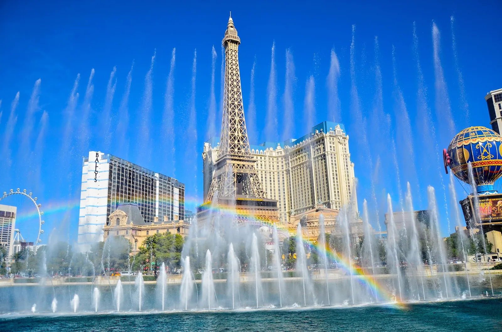 Bellagio fountains with a rainbow and the Paris Eiffel Tower