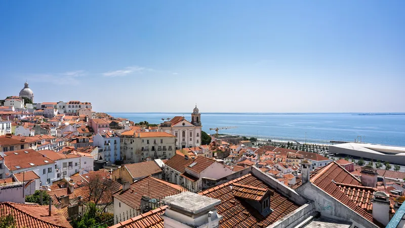 Alfama's terracotta rooftops tumbling down to the Tagus