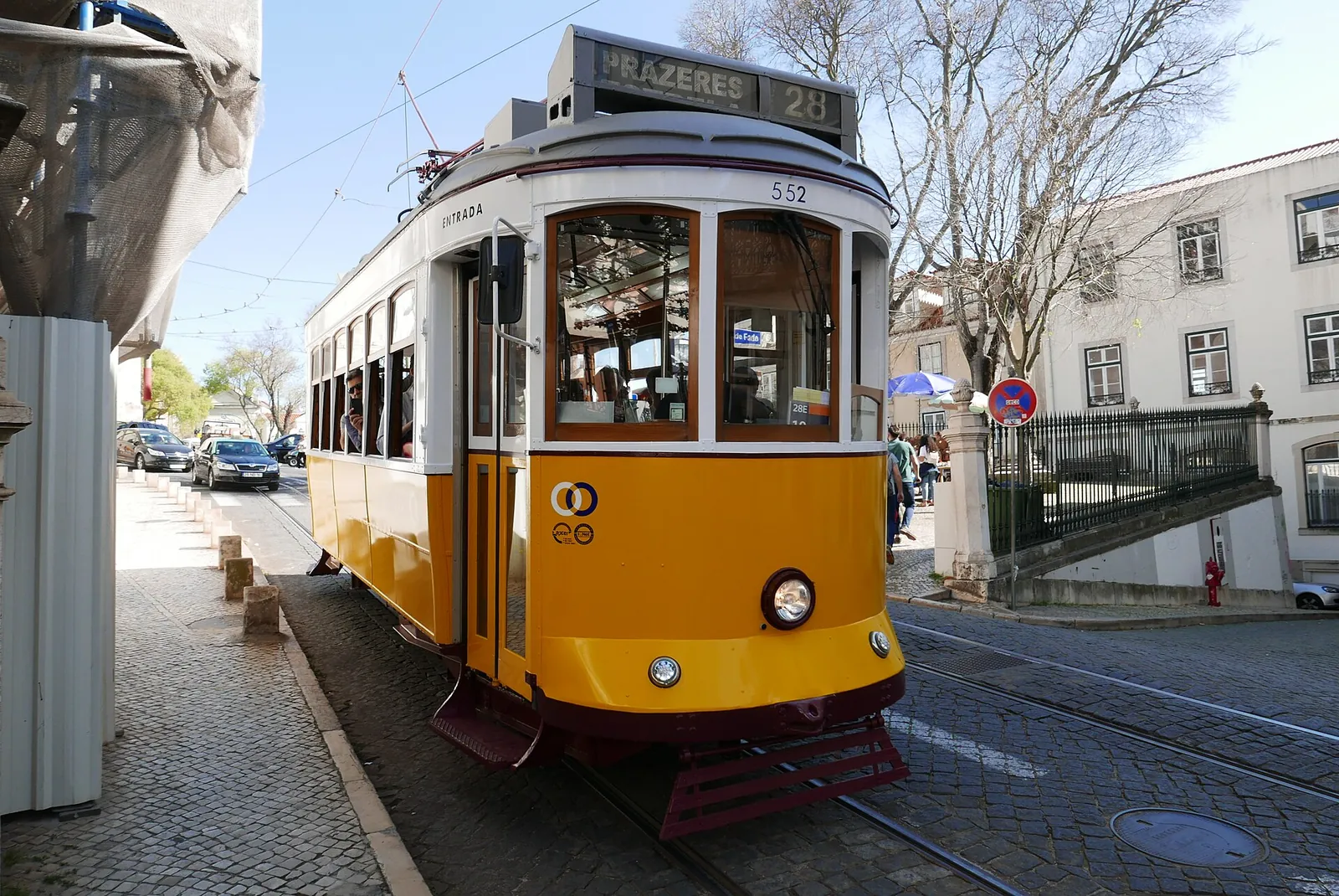 Yellow tram 28 bound for Prazeres on a Lisbon street
