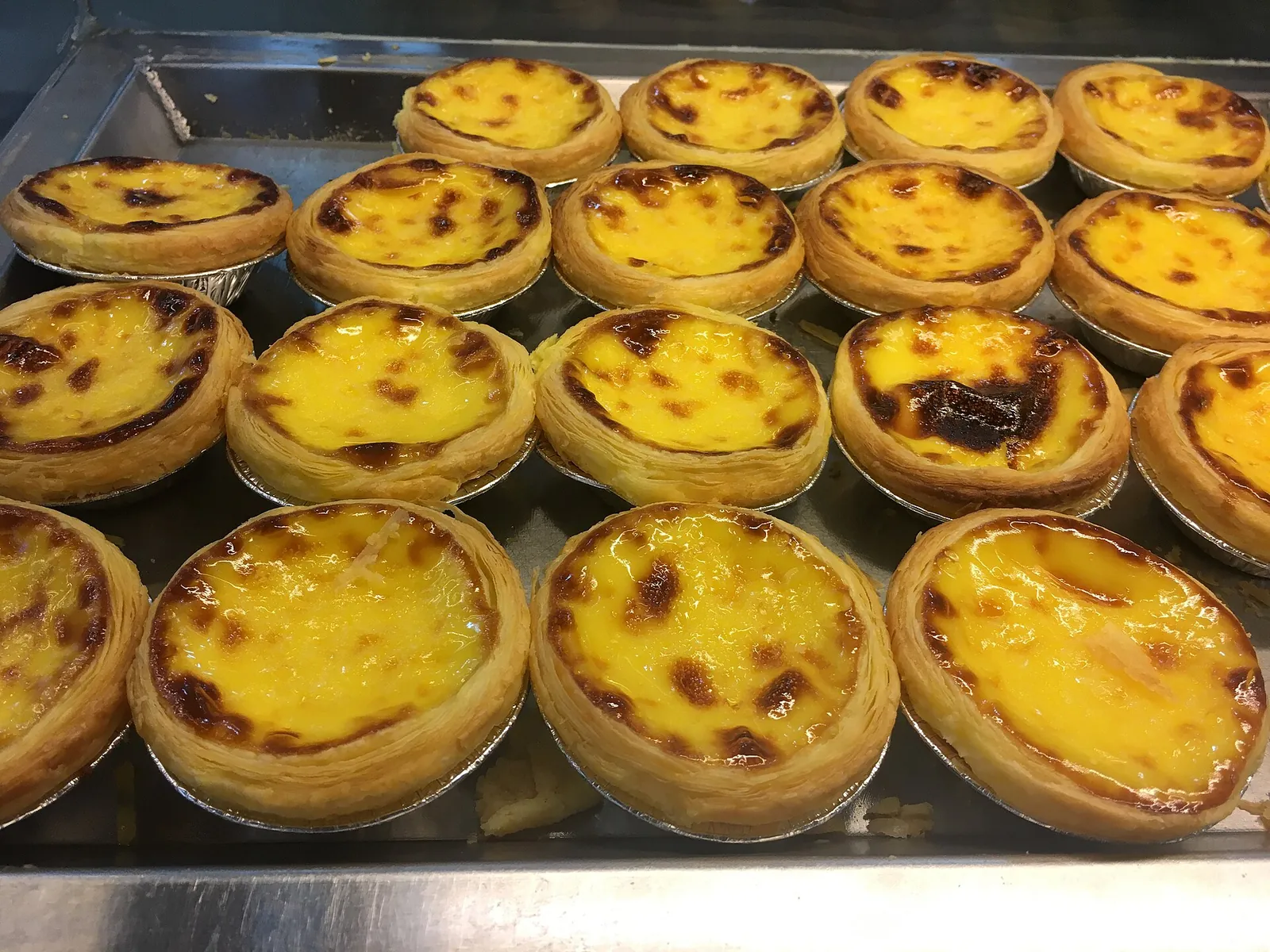 A tray of golden Portuguese-style egg tarts