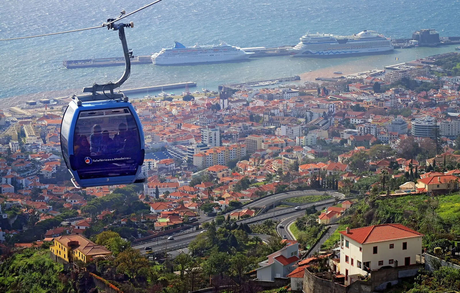 A cable car gliding high above Funchal's rooftops