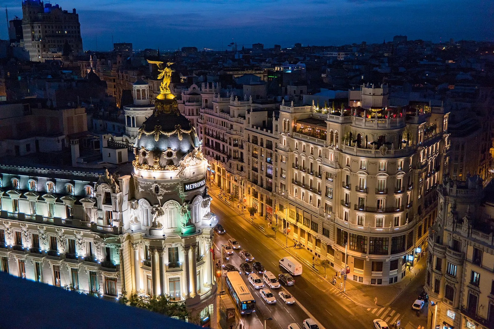 The Metropolis building and Gran Vía lit up at dusk, Madrid