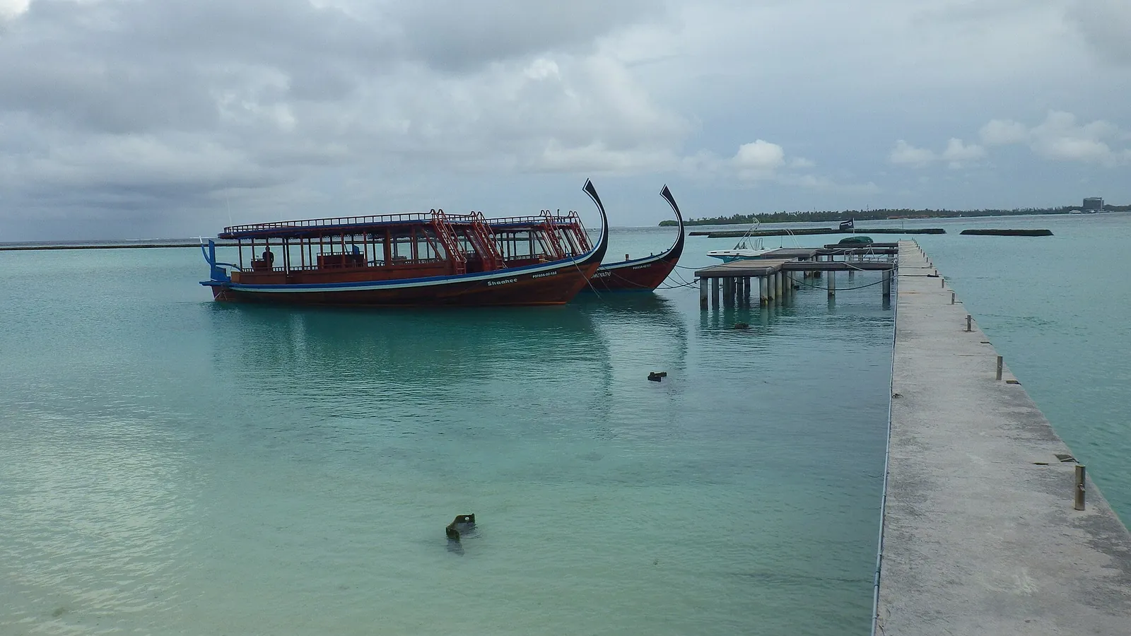 Traditional dhonis moored by a jetty on a local island