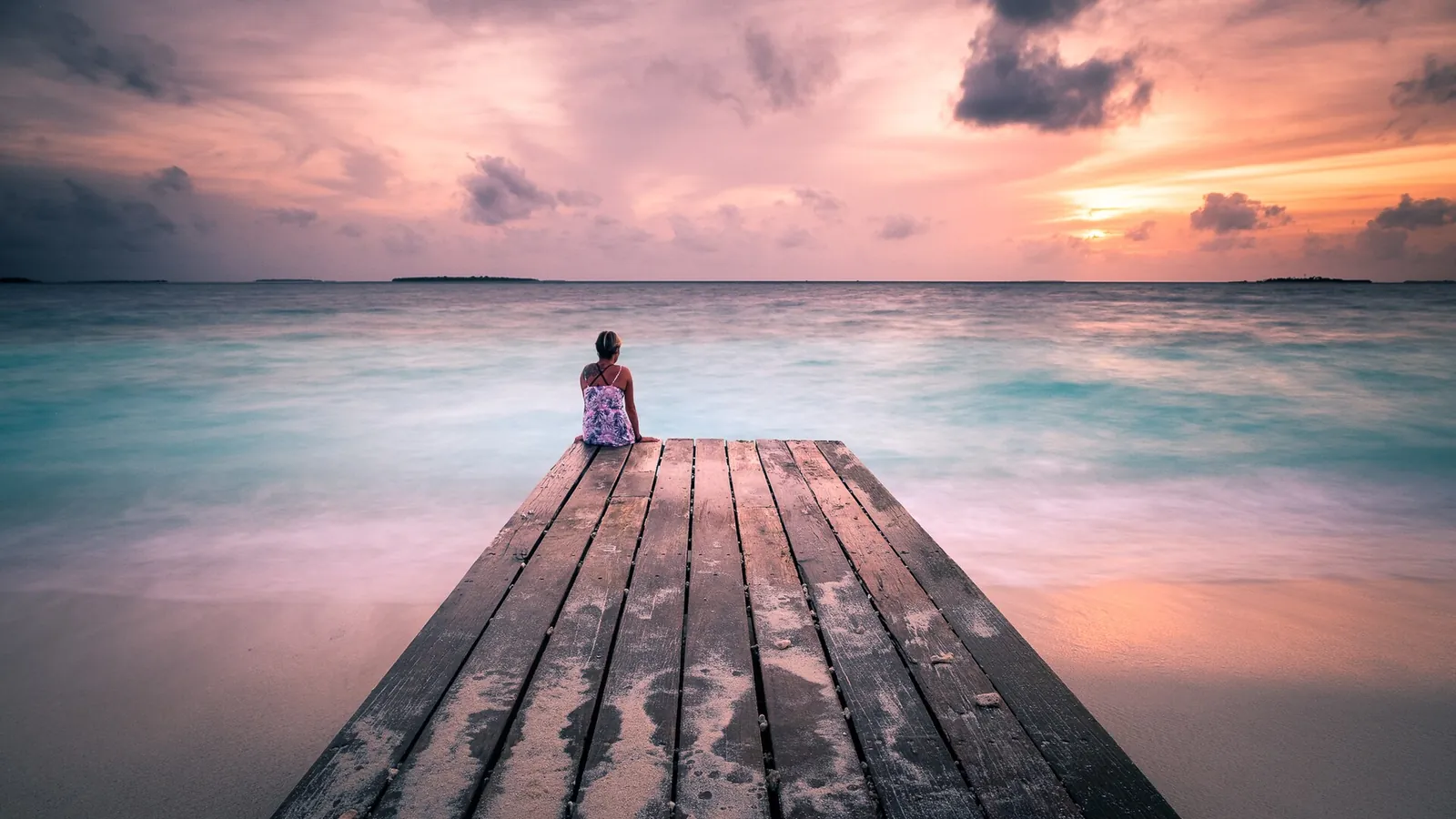 Pink sunset sky over a wooden jetty