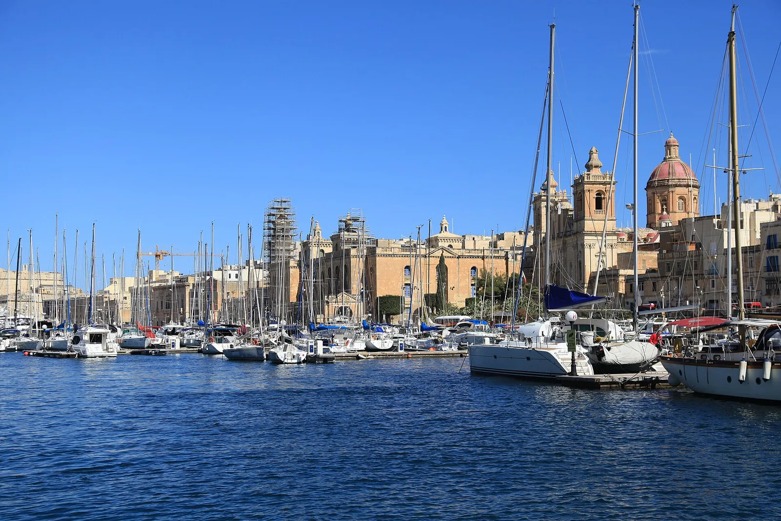 Yachts in Birgu marina under a bright blue sky