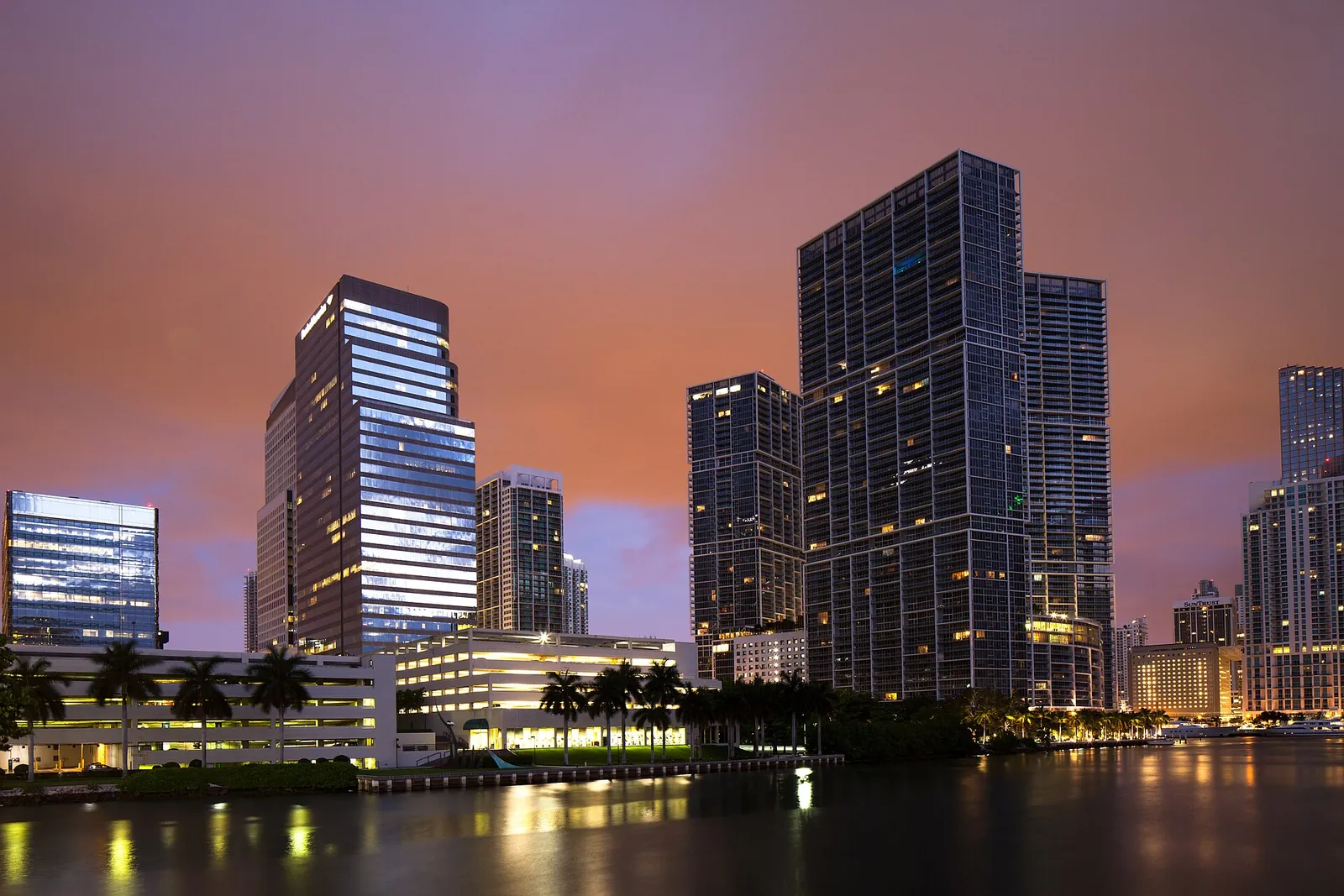 Brickell towers glowing at dusk over the water