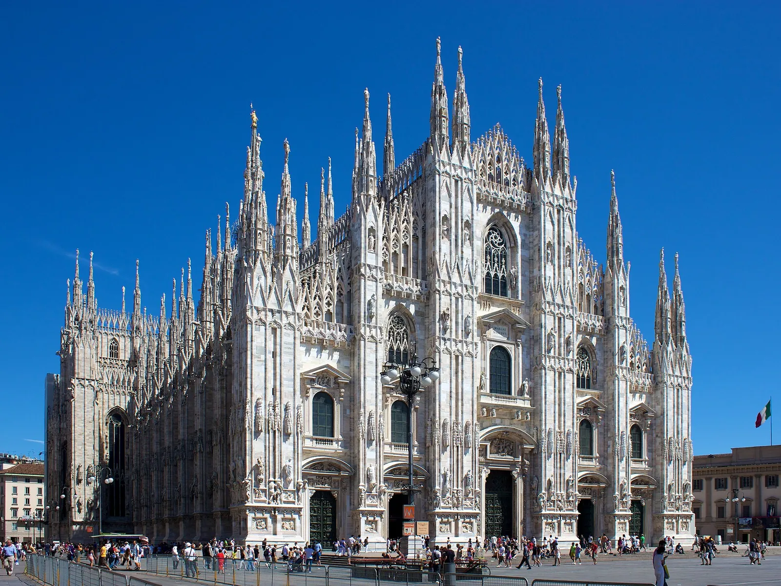 Milan's white marble Duomo under a deep blue sky