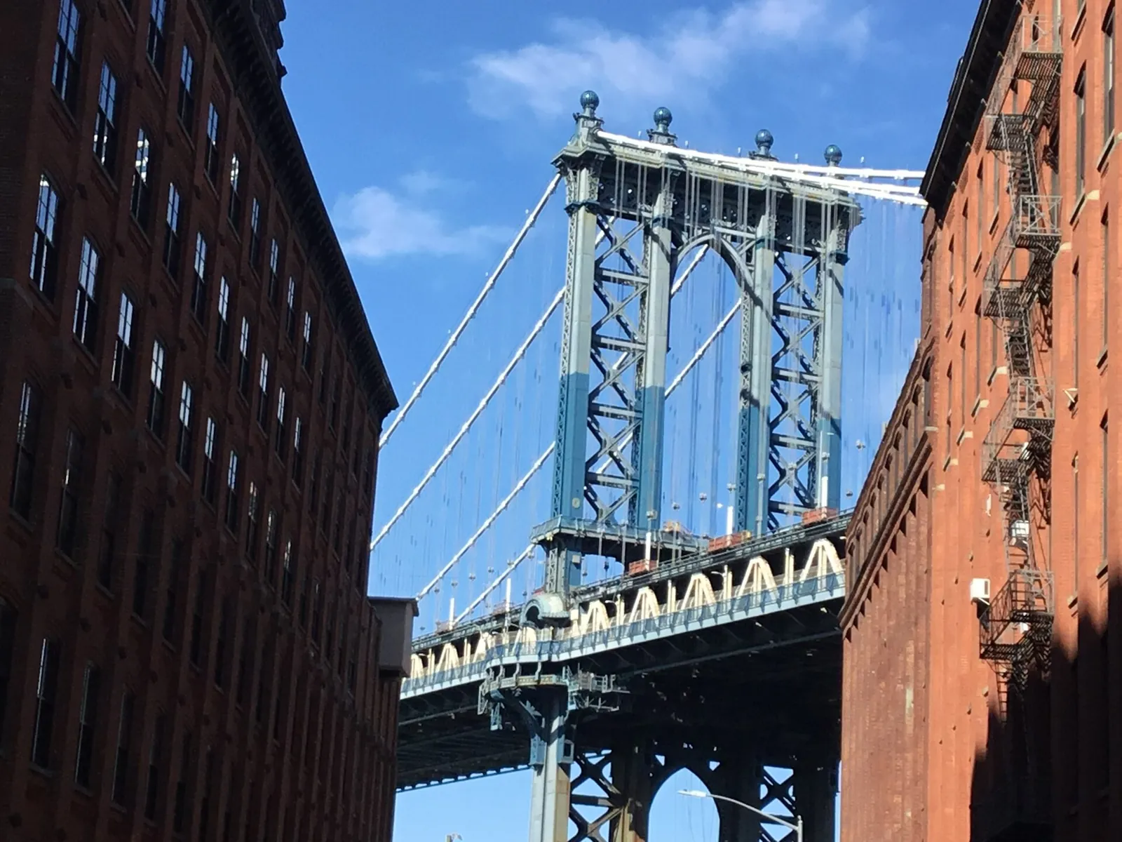 Manhattan Bridge framed by DUMBO's red brick buildings