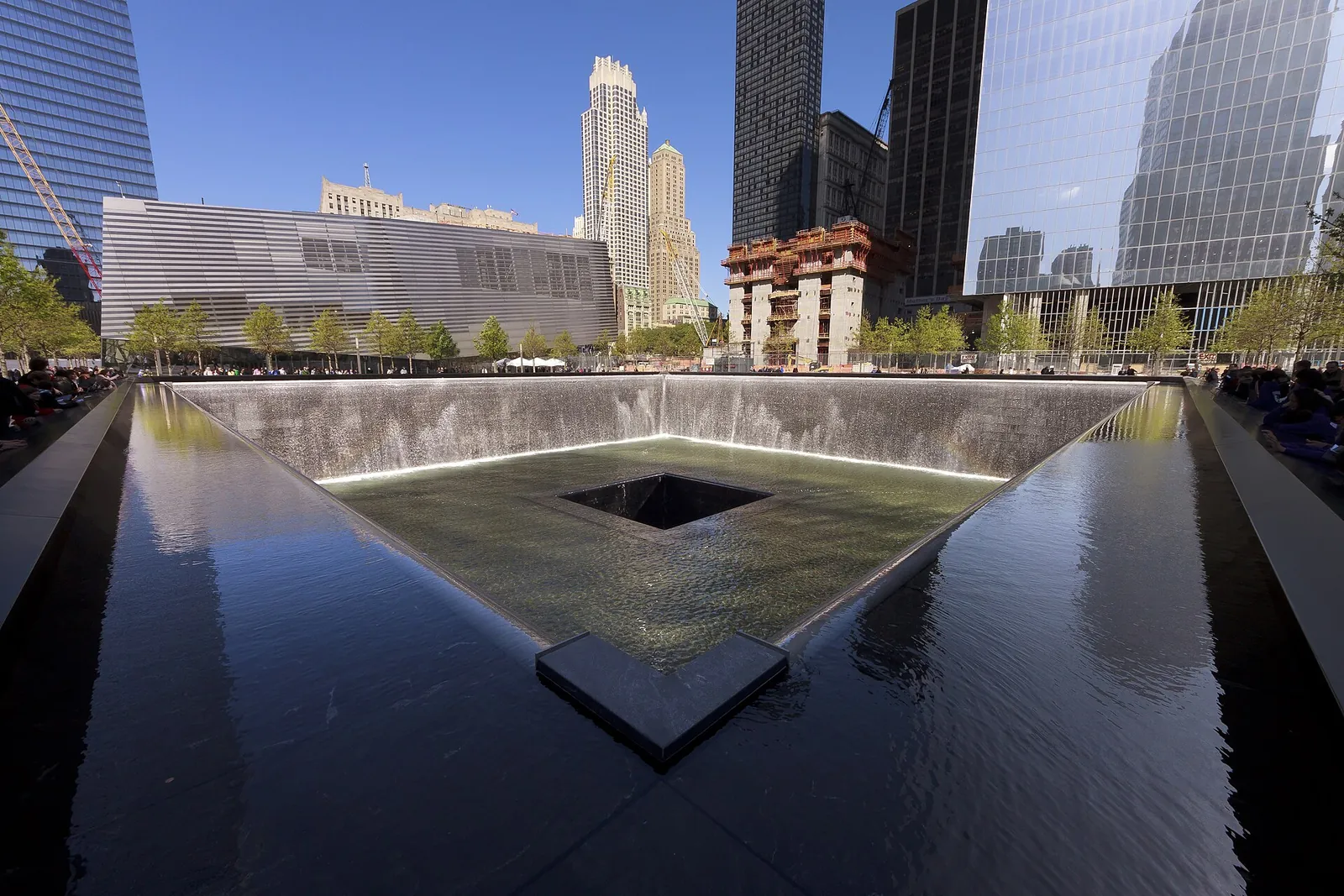 9/11 Memorial reflecting pool under a blue sky
