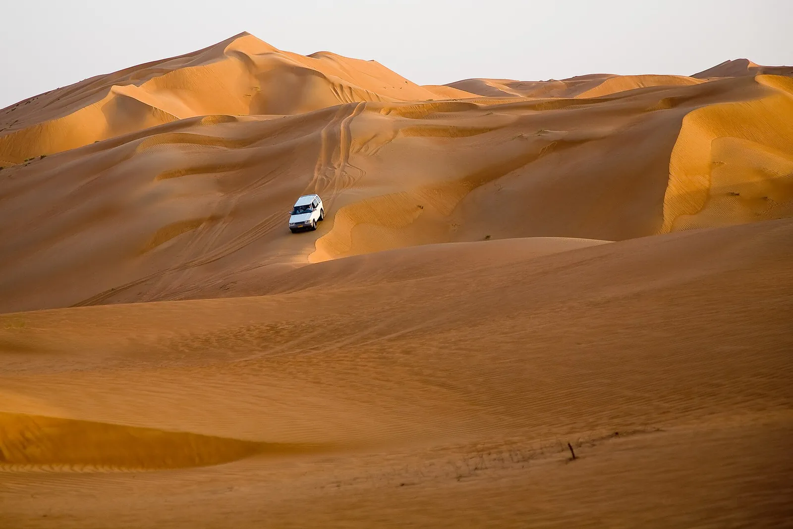 A 4x4 crossing the orange dunes of Wahiba Sands