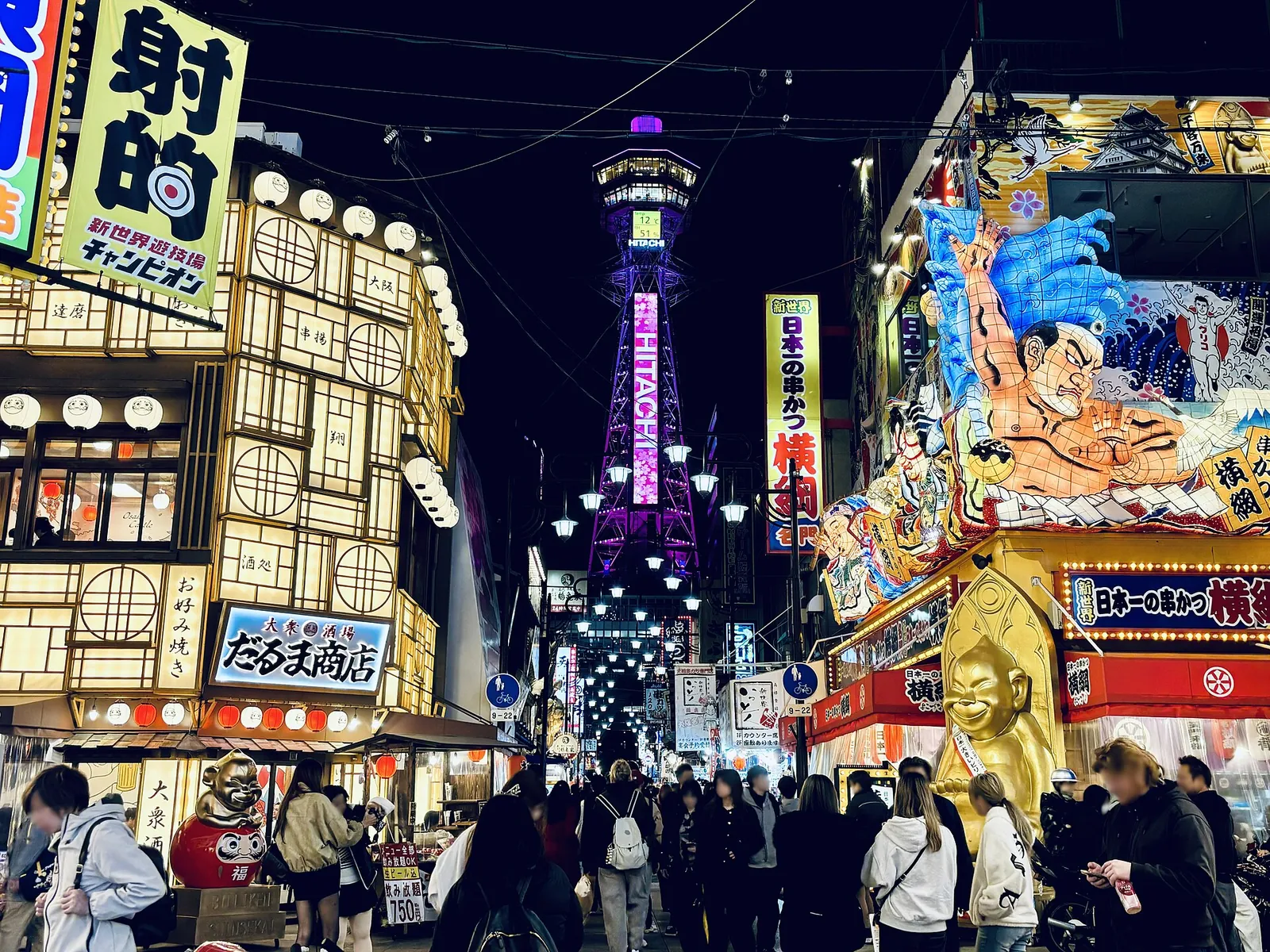 Retro signs of Shinsekai lit up below Tsutenkaku Tower