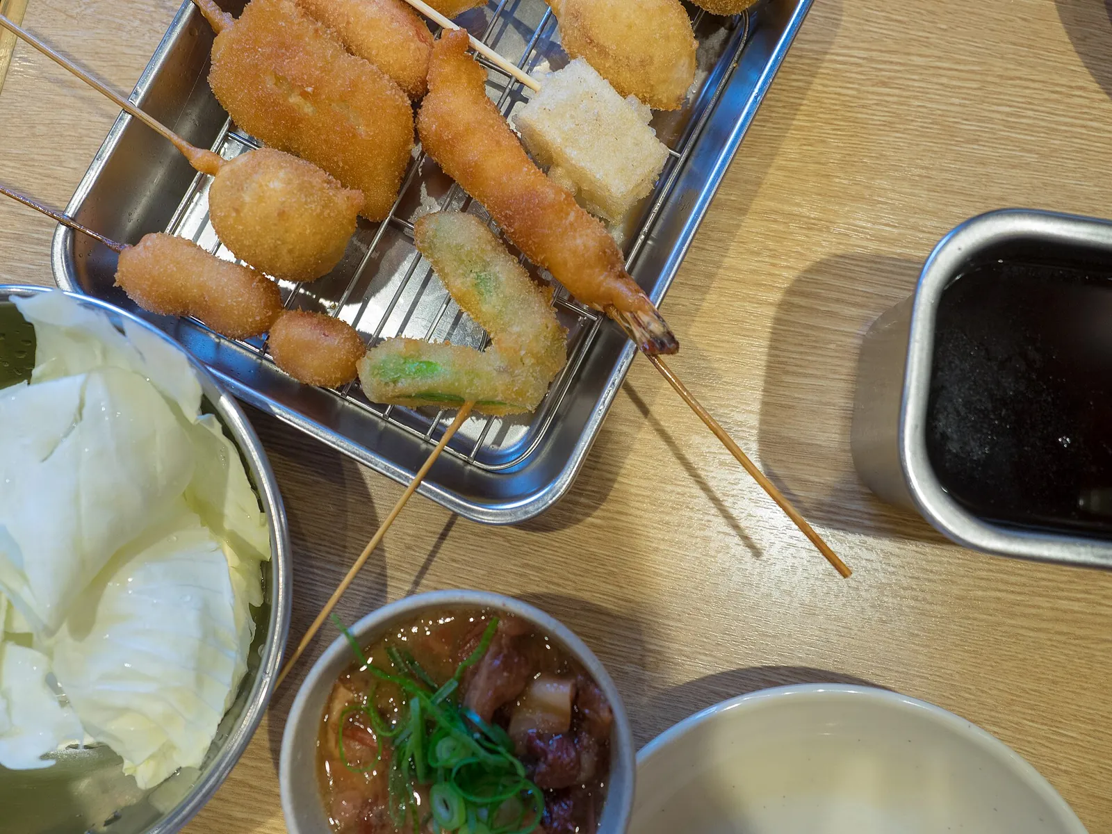 Golden kushikatsu skewers with dipping sauce in Shinsekai